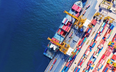 Overhead image of cargo ship docking with colourful cargo freight containers
